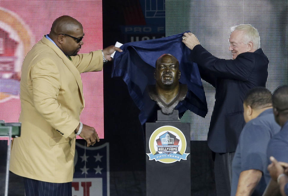 FILE - Former NFL football player Larry Allen, left, and Dallas Cowboys owner Jerry Jones unveil the bust of Allen during the induction ceremony at the Pro Football Hall of Fame, Aug. 3, 2013, in Canton, Ohio. Allen, one of the most dominant offensive linemen in the NFL during a 12-year career spent mostly with the Dallas Cowboys, died suddenly on Sunday, June 2, 2024, while on vacation with his family in Mexico, the Cowboys said. He was 52. (AP Photo/Tony Dejak, File)