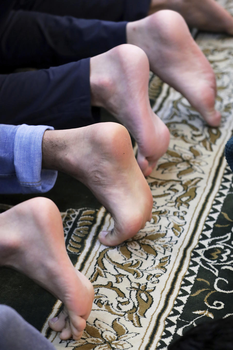 Brothers Abdul Wasi Safi, left, and , right, pray barefoot during Friday prayers at the Al-Noor Society Mosque in Houston, on April 7, 2023. Abdul, who had suffered injuries while assisting the U.S. military in Afghanistan during the war, has recently arrived in Houston after being detained for months, but has no documentation allowing him to begin a normal life with his brother Samiullah. (AP Photo/Michael Wyke)