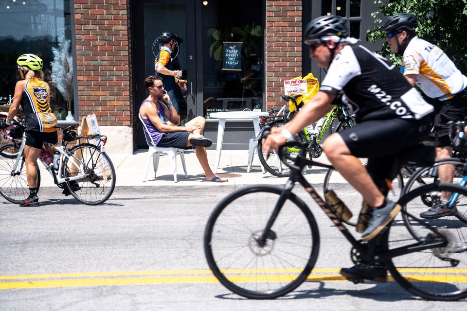 Riders roll along Walnut Street during RAGBRAI 50 on Wednesday, July 26, 2023, in downtown Des Moines.