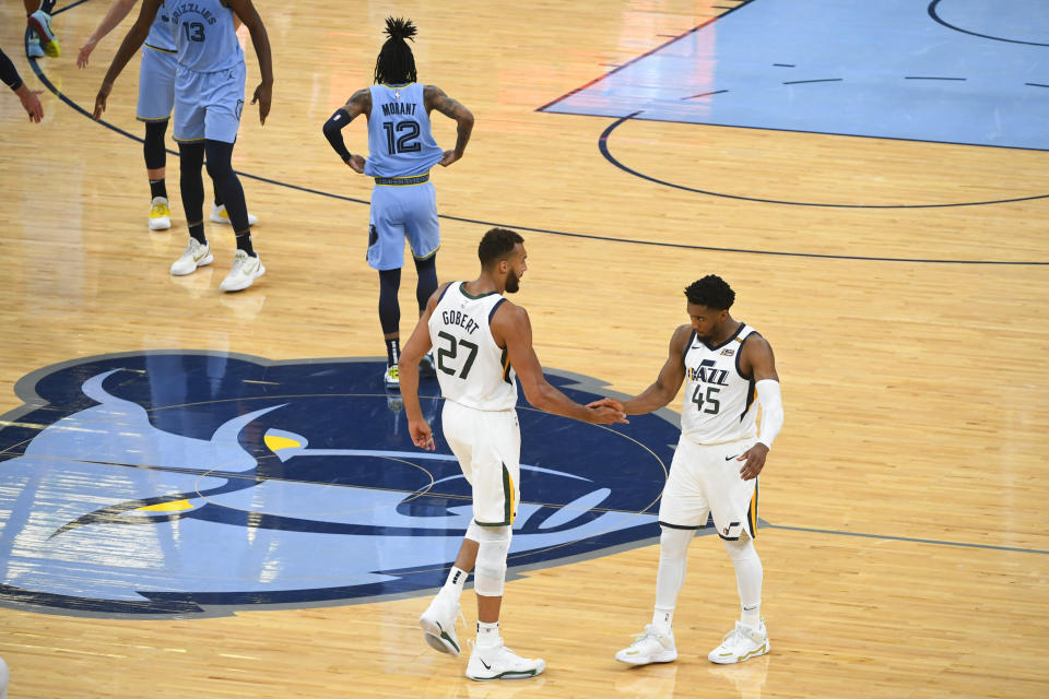 Utah Jazz center Rudy Gobert (27) and guard Donovan Mitchell (45) congratulate each other at the end of Game 3 of an NBA basketball first-round playoff series against the Memphis Grizzlies, Saturday, May 29, 2021, in Memphis, Tenn. Utah won 121-111. (AP Photo/John Amis)