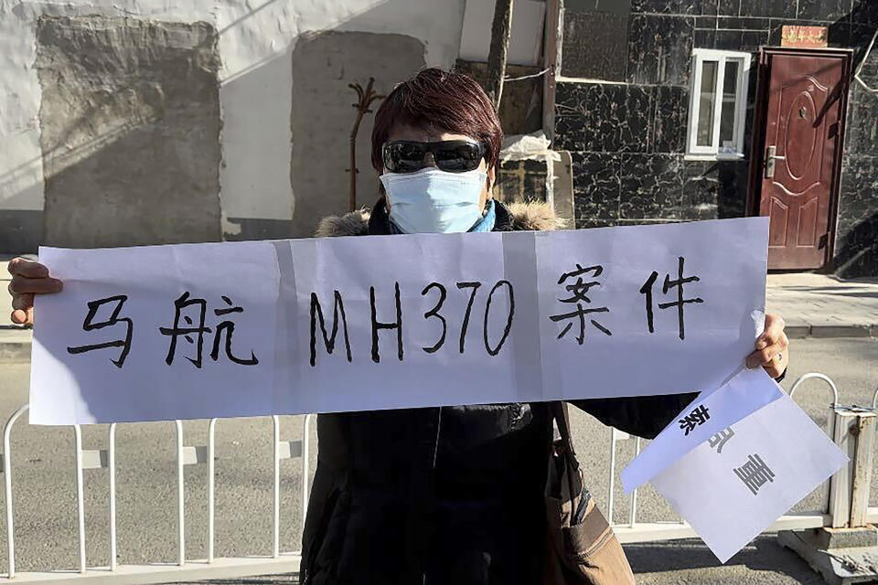 Hu Xiufang, whose son, daughter-in-law and granddaughter were on the missing MH370, hold a banner in Beijing Monday, Nov. 27, 2023. A Beijing court began compensation hearings Monday morning for Chinese relatives of people who died on a Malaysia Airlines plane that disappeared in 2014 on a flight to Beijing, a case that remains shrouded in mystery after almost a decade. The banner reads "Malaysian Airline MH370 case." (AP Photo/Ng Han Guan)