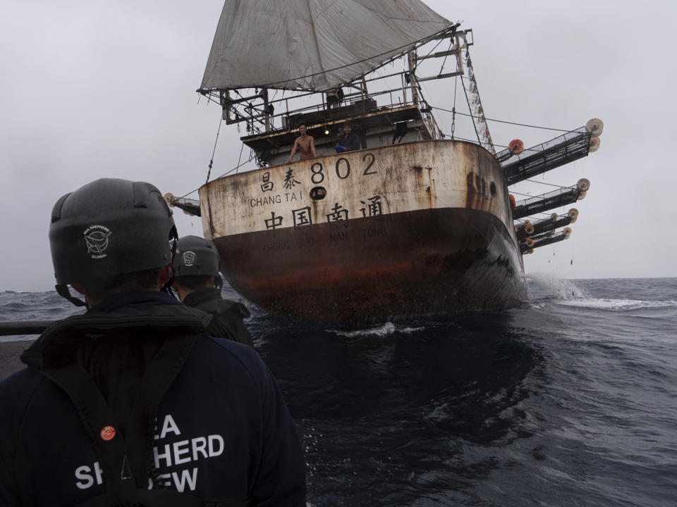 In this July 2021 photo provided by Sea Shepherd, crew members of the Ocean Warrior approach the Chang Tai 802, a Chinese-flagged vessel whose Indonesian crew said they had been stuck at sea for years. During an at-sea encounter, an Indonesian crew member screamed from the stern of the vessel “I want to go home.” The Chang Tai 802 fished for more than year and finally returned to port in China in August 2022, according to research by the Peruvian fishing consultancy Artisonal. (Isaac Haslam/Sea Shepherd via AP)