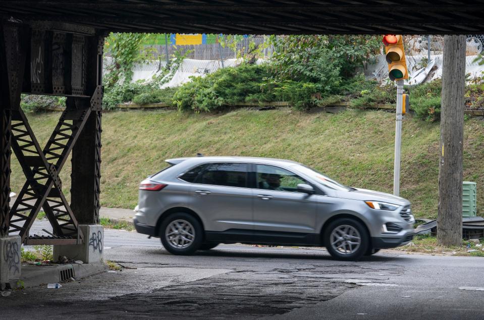 A car passes a train track bypass known as “the valley” near the North Brookside Park neighborhood of Indianapolis, Thursday, Sept. 21, 2023.