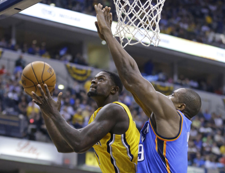 Indiana Pacers guard Lance Stephenson, left, shoots under Oklahoma City Thunder forward Serge Ibaka in the second half of an NBA basketball game in Indianapolis, Sunday, April 13, 2014. The Pacers defeated the Thunder 102-97. (AP Photo/Michael Conroy)