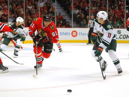 May 11, 2014; Chicago, IL, USA; Chicago Blackhawks right wing Marian Hossa (81) and Minnesota Wild left wing Zach Parise (11) skate for the puck during the third period of game five of the second round of the 2014 Stanley Cup Playoffs at the United Center. Chicago won 2-1. Mandatory Credit: Dennis Wierzbicki-USA TODAY Sports