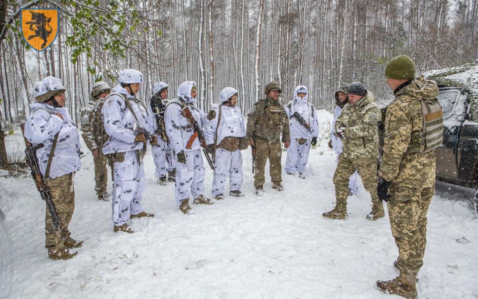 The soldiers receive instructions from officers in an undisclosed forest location