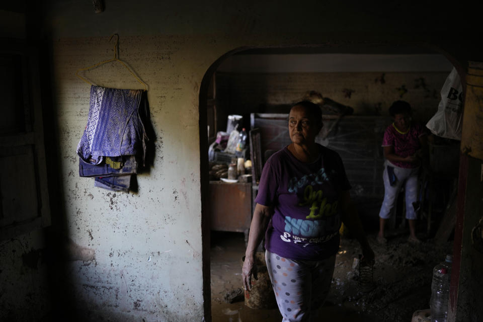 Carmen Fuentes stands in the home she shares with her husband Jose Medina and family after it was flooded in Las Tejerias, Venezuela, Monday, Oct. 10, 2022. A fatal landslide fueled by flooding and days of torrential rain swept through this town in central Venezuela. (AP Photo/Matias Delacroix)