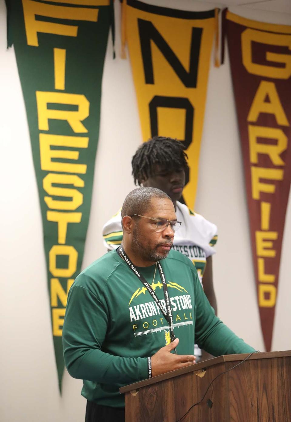 Firestone head football coach Eric Mitchell speaks during the Akron Public Schools Football Media Day as he stands next to Khamoni Jones on Wednesday in Akron. Carlos Humphrey was the other Firestone player in attendance.