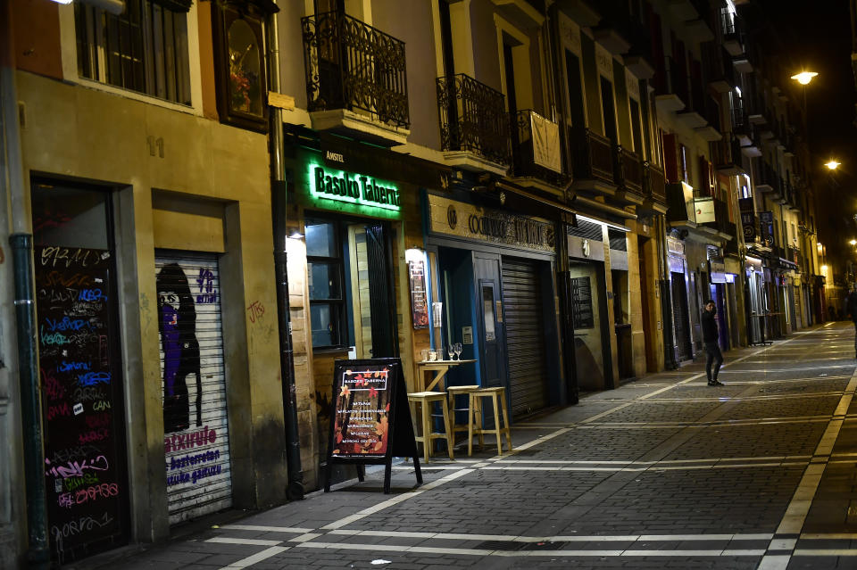 A person walks along the unusually deserted Saint Nicolas street, to prevent the spread of coronavirus, in Pamplona, northern Spain, Friday, March 13, 2020. For most people, the new COVID-19 coronavirus causes only mild or moderate symptoms, such as fever and cough, but for some, especially older adults and people with existing health problems, it can cause more severe illness, including pneumonia. (AP Photo/Alvaro Barrientos)