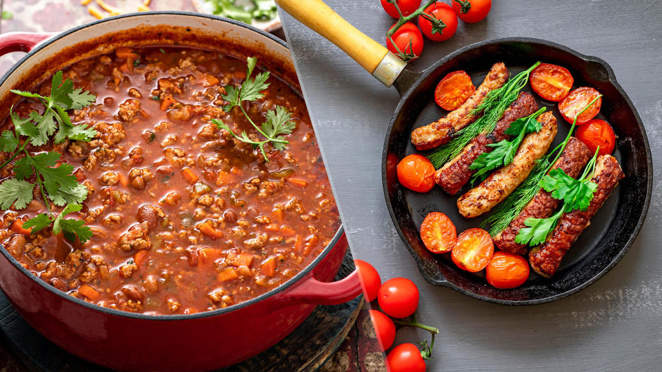  Dutch oven with chilli and cast iron skillet cooking sausages. 