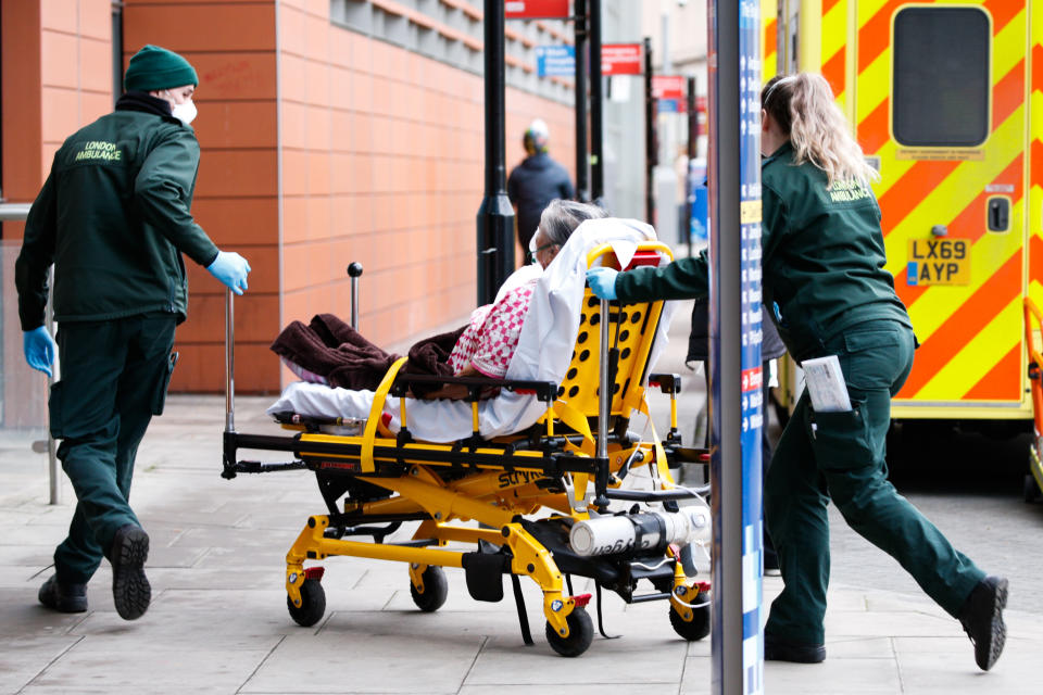 Paramedics wheel a patient wearing an oxygen mask into the emergency department of the Royal London Hospital in London, England, on January 26, 2021. Data from the UK's official statistics bodies revealed today that, based on death certificates, up to January 15 this year nearly 104,000 people have died with coronavirus since the pandemic began. Government figures, which are based on deaths within 28 days of a positive covid-19 test, remain slightly lower, yesterday standing at 98,531. (Photo by David Cliff/NurPhoto via Getty Images)