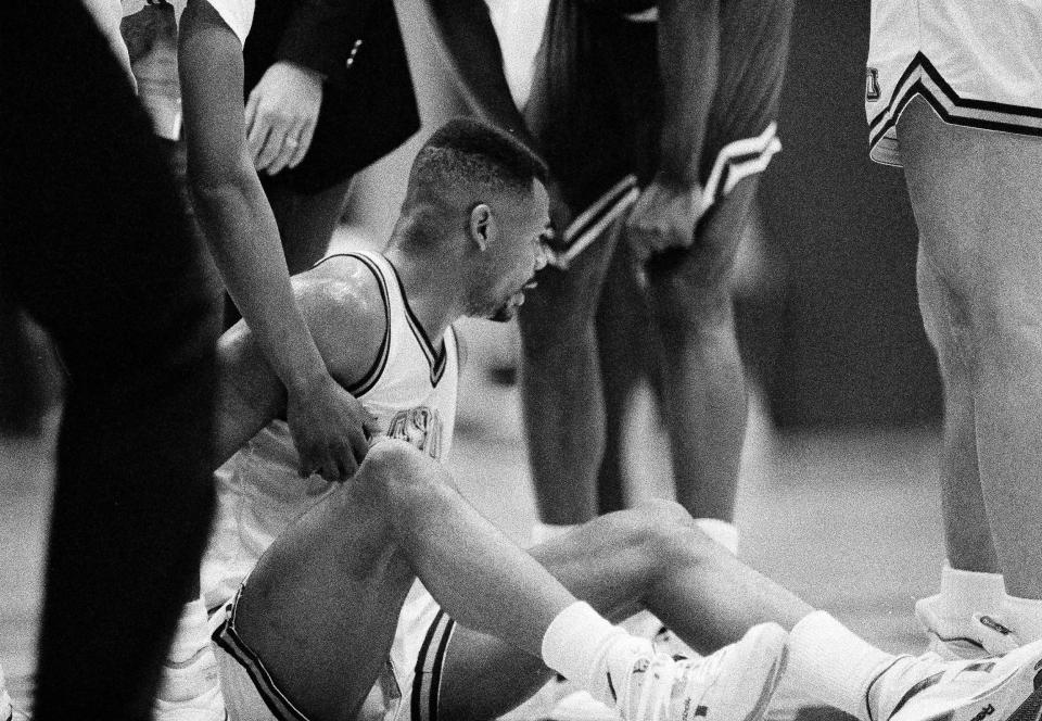 Hank Gathers, one of only two Division I players to lead the nation in scoring and rebounding in the same season, tries to get up after collapsing during Loyola Marymount's West Coast Conference Tournament against Portland in Los Angeles, March 5, 1990. Gathers, 23, died later that evening. (AP Photo/Doug Sheridan)