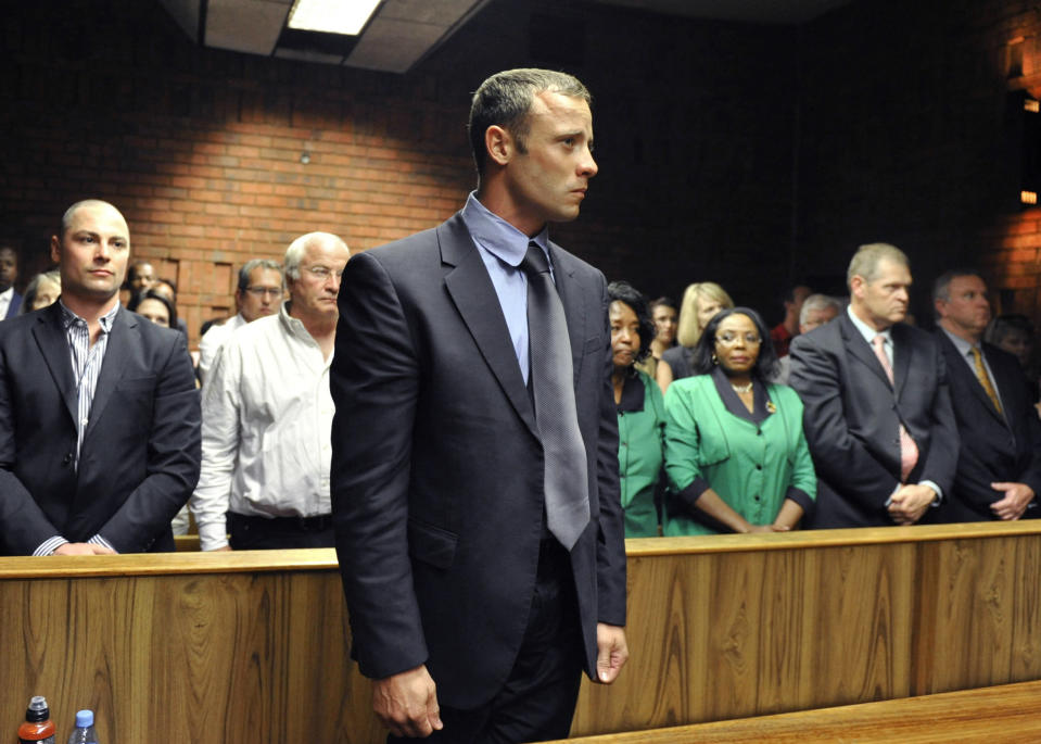 FILE - Olympian Oscar Pistorius stands following his bail hearing in Pretoria, South Africa, Tuesday, Feb. 19, 2013. Pistorius could be granted parole on Friday, Nov. 24, 2023 after nearly 10 years in prison for killing his girlfriend. The double-amputee Olympic runner was convicted of a charge comparable to third-degree murder for shooting Reeva Steenkamp in his home in 2013. He has been in prison since late 2014. (AP Photo, File)