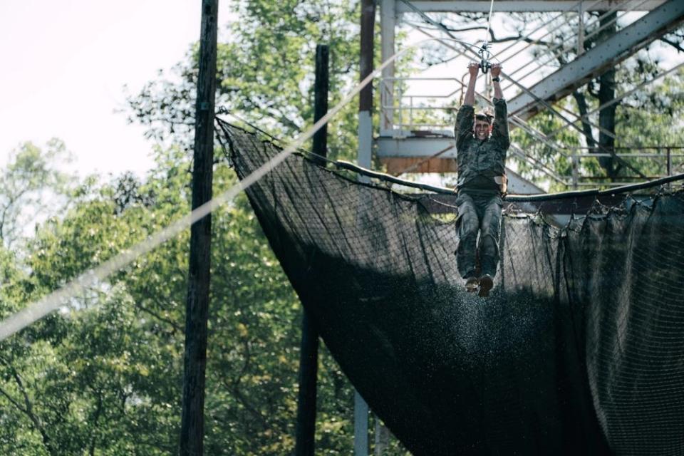 A Best Ranger competitor propels down a zipline during an obstacle course.