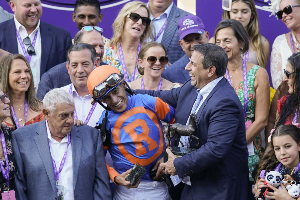 Jockey John Velazquez, in orange and blue, jokes with owner Mike Repole of Repole Stables after riding Fierceness to win the Breeders' Cup Juvenile horse race Friday, Nov. 3, 2023 at Santa Anita Park in Arcadia, Calif. (AP Photo/Ashley Landis)