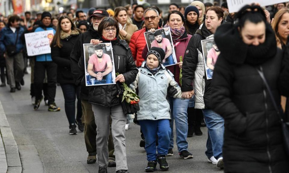 Friends and relatives hold up photos of one of the victims of the shooting in Hanau