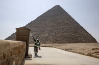 Un trabajador realiza tareas de desinfección en la Necrópolis de Guiza (Egipto) el 25 de marzo. (Foto: Nariman El-Mofty / AP).