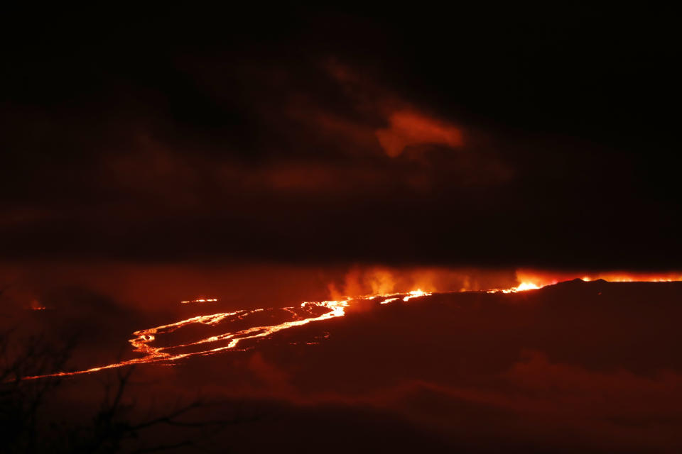 A river of lava flows down from Mauna Loa, Monday, Nov. 28, 2022, near Hilo, Hawaii. Mauna Loa, the world's largest active volcano erupted Monday for the first time in 38 years. (AP Photo/Marco Garcia)