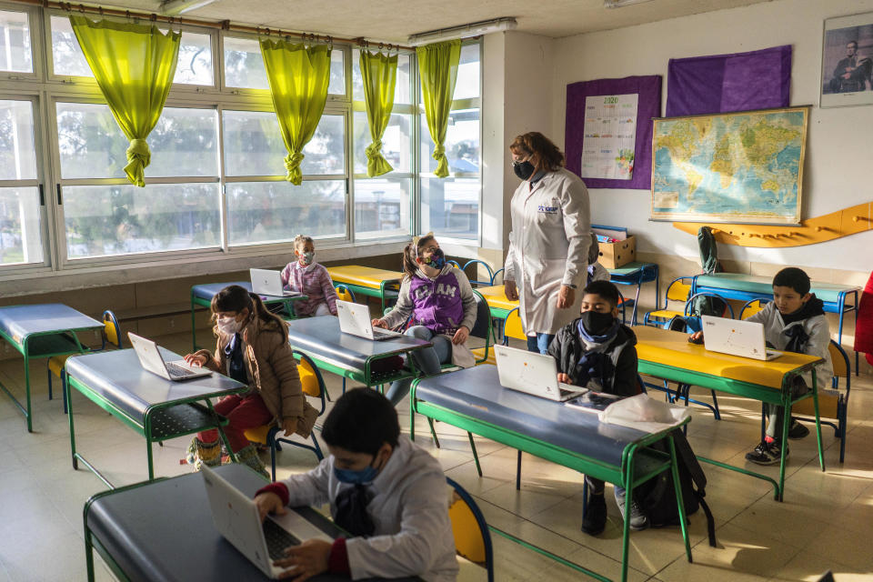 Estudiantes con mascarillas protectoras asisten a clases en una escuela pública en Montevideo, Uruguay, el lunes 15 de junio de 2020. La vida en Uruguay está volviendo lentamente a la normalidad mientras que América Latina todavía está en medio de la tormenta del coronavirus. AP Foto/Matilde Campodonico)