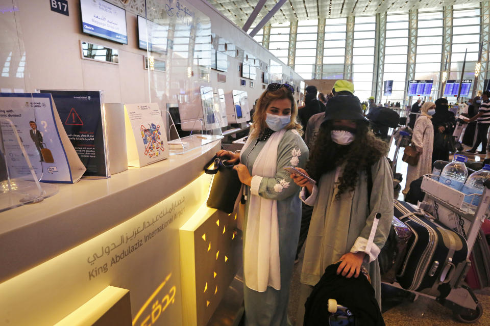 In this May 17, 2021 photo, Saudi passenger Safinaz Abdel Gawwad, left, checks her baggage before boarding a flight to Egypt for tourism, at King Abdulaziz International Airport in Jiddah, Saudi Arabia. The cloud of social restrictions that loomed over generations of Saudis is quickly dissipating and the country is undergoing visible change. Still, for countless numbers of people in the United States and beyond, Saudi Arabia will forever be associated with 9/11. (AP Photo/Amr Nabil)