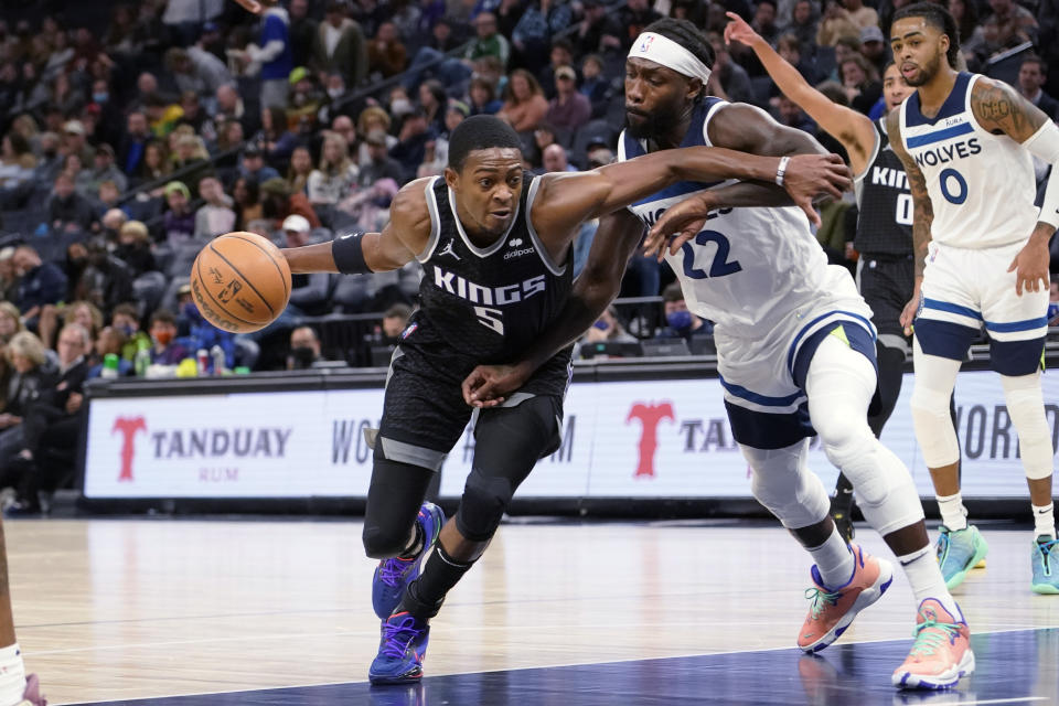 Sacramento Kings guard De'Aaron Fox drives past Minnesota Timberwolves guard Patrick Beverley during the second half of an NBA basketball game Wednesday, Nov. 17, 2021, in Minneapolis. The Timberwolves won 107-97. (AP Photo/Craig Lassig)