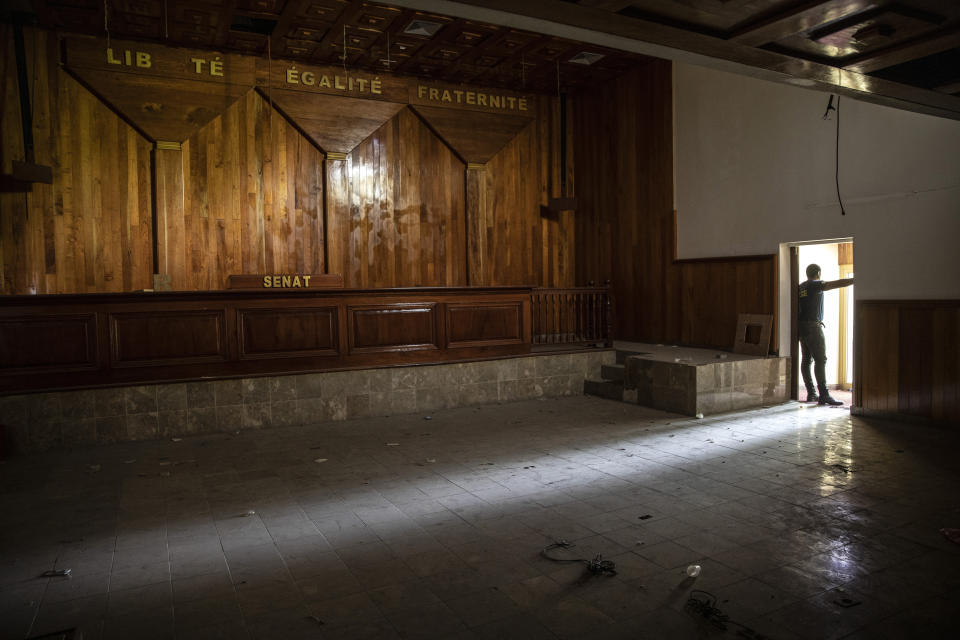 FILE - A policeman stands in the entrance of the deserted Senate chambers, inactive for over a year, in Port-au-Prince, Haiti, Sept. 22, 2021. Nearly all the seats in parliament are vacant and there's no firm date yet for long-delayed elections. (AP Photo/Rodrigo Abd, File)