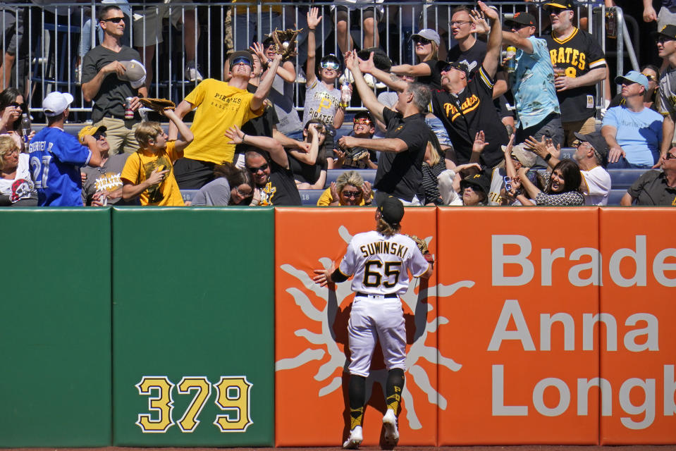 Pittsburgh Pirates left fielder Jack Suwinski (65) watches as a fan catches a solo-home run hit by San Francisco Giants' Wilmer Flores during the first inning of a baseball game in Pittsburgh, Saturday, June 18, 2022. (AP Photo/Gene J. Puskar)