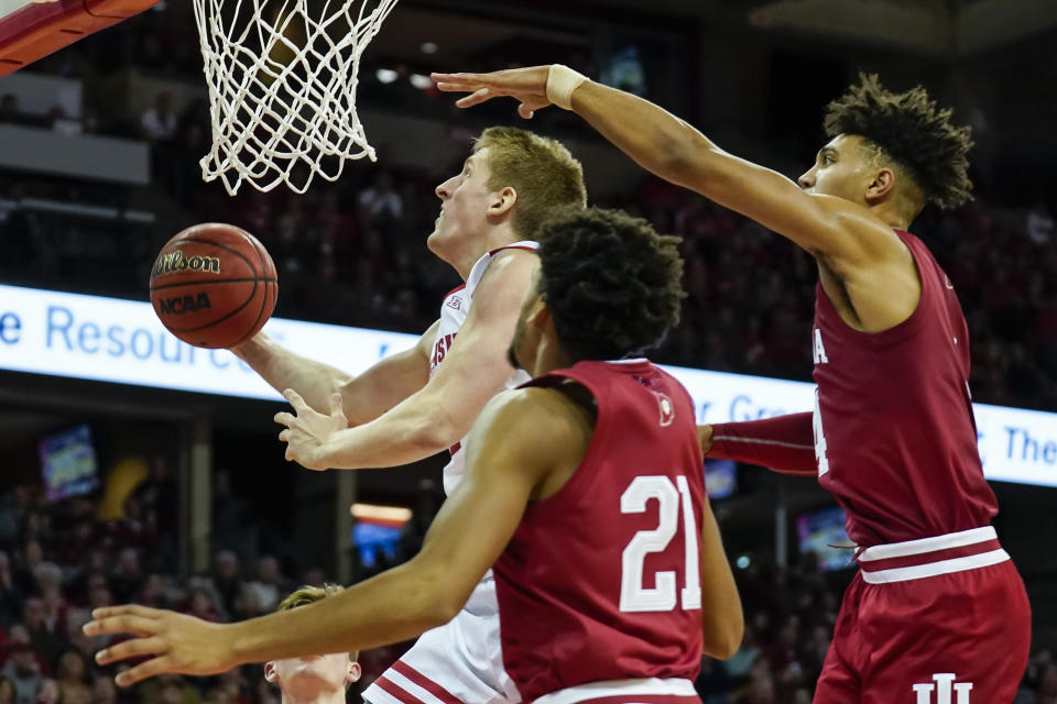 Wisconsin's Brevin Pritzl, left, shoots past Indiana's Jerome Hunter (21) and Aljami Durham, right, during the second half of an NCAA college basketball game Saturday, Dec. 7, 2019, in Madison, Wis. Wisconsin won 84-64. (AP Photo/Andy Manis)