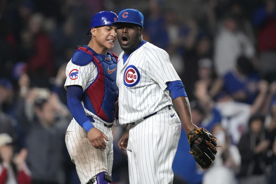 Chicago Cubs catcher Miguel Amaya, left, and relief pitcher Héctor Neris celebrate the team's 7-5 win over the Cincinnati Reds in a baseball game that ended early Sunday, June 2, 2024, in Chicago. (AP Photo/Charles Rex Arbogast)