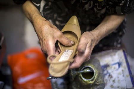 Owner Arturo Azinian works in his shoe repair shop in Beverly Hills, California April 24, 2015. REUTERS/Mario Anzouni