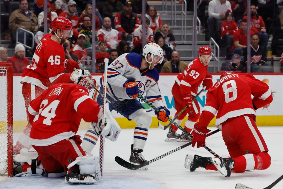 Edmonton Oilers center Connor McDavid (97) skates with the puck in front of Detroit Red Wings goaltender Alex Lyon (34) and defenseman Ben Chiarot (8) in the first period at Little Caesars Arena in Detroit on Thursday, Jan. 11, 2024.