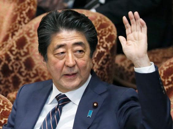 Japanese prime minister Shinzo Abe raises his hand during a parliamentary session at the Lower House in Tokyo, Japan, on 18 February 2019. (AP)