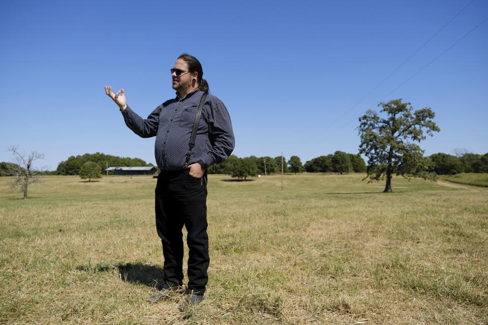 Ryan Mackey speaks about his spiritual connection to bison while visiting the herd in Bull Hollow, Okla., on Sept. 27, 2022. “We don’t speak the same language as the bison,” Mackey says. “But when you sit with them and spend time with them, relationships can be built on … other means than just language alone: sharing experiences, sharing that same space and just having a feeling of respect. Your body language changes when you have respect for someone or something.” (AP Photo/Audrey Jackson)