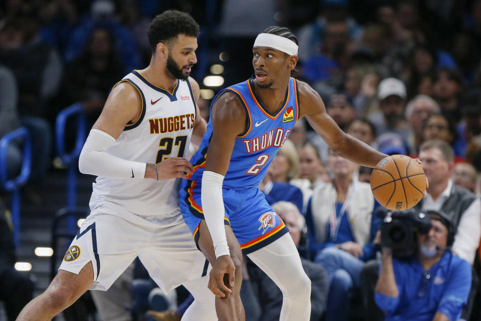 Oklahoma City Thunder guard Shai Gilgeous-Alexander (2) dribbles as Denver Nuggets guard Jamal Murray (27) defends in the first half of an NBA basketball game, Sunday, Oct. 29, 2023, in Oklahoma City. (AP Photo/Nate Billings)