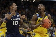 Marquette's Darryl Morsell looks to shoot against Xavier's Nate Johnson (10) during the first half of an NCAA college basketball game Sunday, Jan. 23, 2022, in Milwaukee. (AP Photo/Aaron Gash)