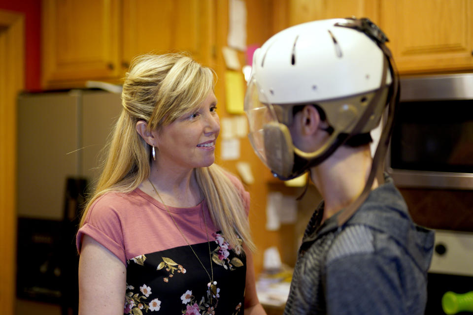 In this April 11, 2019 photo, Shelley Gillen is photographed in her Bellevue, Neb., home with her 17-year-old son, Will, who wears a helmet to protect him from damage during debilitating seizures. Gillen advocates the legalization of medical marijuana that could help her son's seizures. Nebraska's conservative lawmakers are poised to once again reject measures calling for allowing limited and highly regulated use of medical marijuana, but their decision this year could have the unintended consequence of ushering in one of the most unrestricted medical marijuana laws in the country. (AP Photo/Nati Harnik)