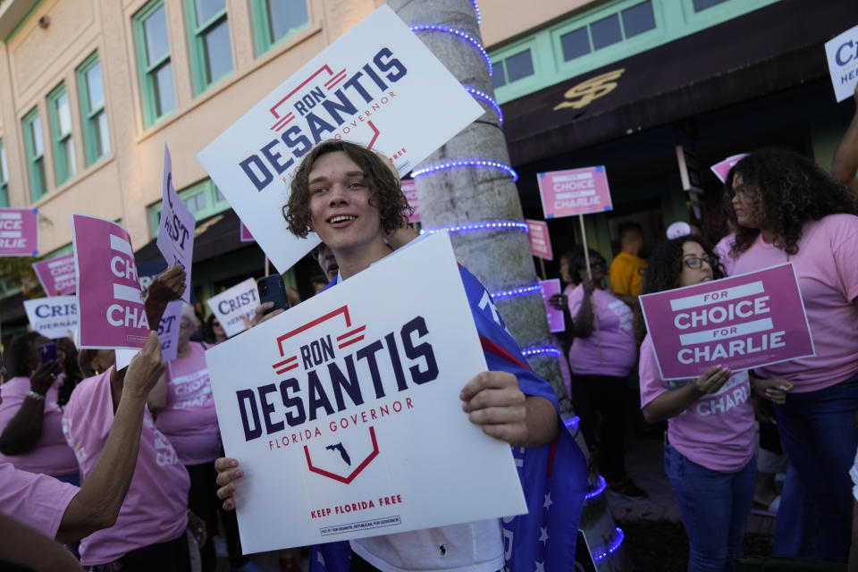 Supporters of Democratic candidate for governor Charlie Crist and Florida's Republican Gov. Ron DeSantis stand outside the Sunrise Theatre ahead of their debate, in Fort Pierce, Fla., Monday, Oct. 24, 2022.(AP Photo/Rebecca Blackwell)