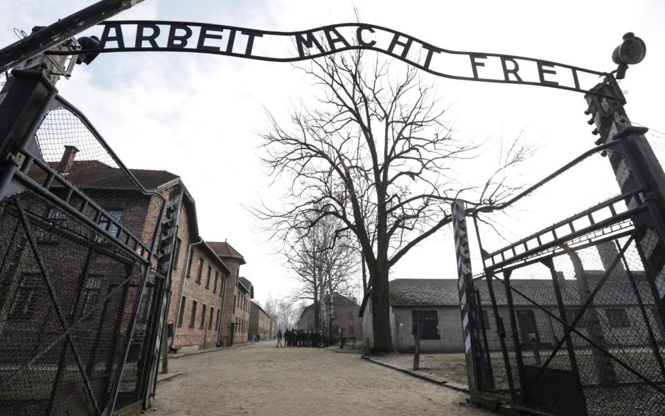 FILE - In this Friday, Feb. 15, 2019 file photo an entrance gate at the Nazi concentration camp Auschwitz-Birkenau is pictured in Oswiecim, Poland. The sign over the gate reads "work makes one free". Germany has agreed to provide more than a half billion euros to aid Holocaust survivors struggling under the burdens of the coronavirus pandemic, the organization that negotiates compensation with the German government said Wednesday. (AP Photo/Michael Sohn,file) - Michael Sohn/AP