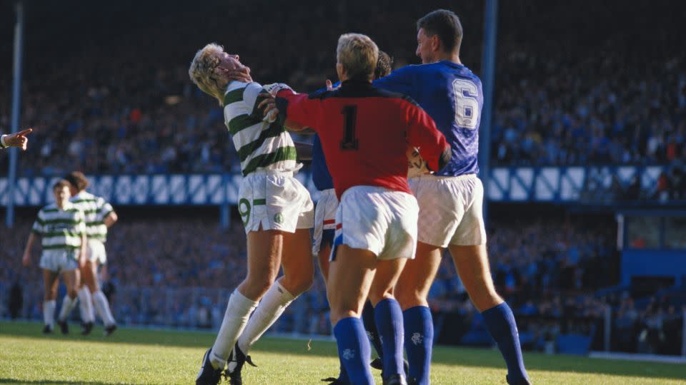 Frank McAvennie of Celtic is grabbed by the throat by a Rangers player as Chris Woods #1 and Terry Butcher #6 also of Rangers step in during the Scottish Premier League match at Ibrox Stadium in Glasgow, Scotland, 1985. - Chris Cole/Getty Images