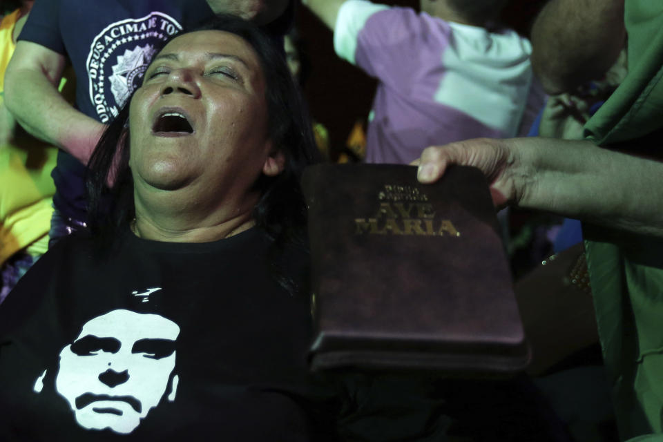 A supporter of presidential frontrunner Jair Bolsonaro of the Social Liberal Party, pray as they wait for the first results of the vote counting of the presidential elections, in front of the headquarters of the national congress, in Brasilia, Brazil, Sunday, Oct. 7, 2018. In addition to voting for president, Brazilians are also deciding congressional races and electing state governors. (AP Photo / Eraldo Peres)