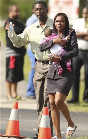 Children who were in the day care are brought out by parents hours after several children were injured after being struck by a vehicle at a KinderCare Learning Center in Winter Park, Florida April 9, 2014. REUTERS/Stephen M. Dowell/Orlando Sentinel