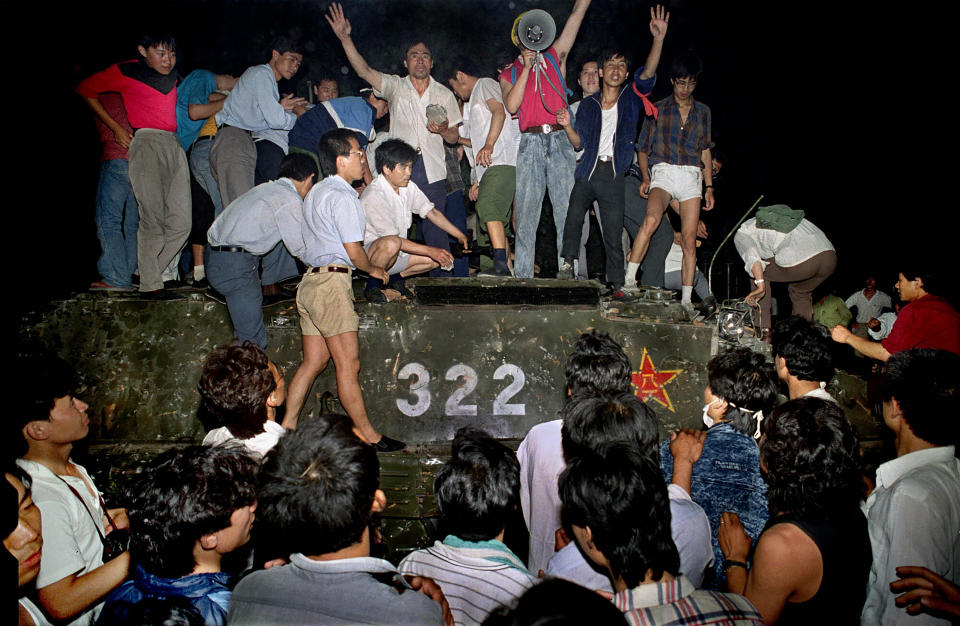 FILE - Civilians hold rocks as they stand on a government armored vehicle near Chang'an Boulevard in Beijing, early June 4, 1989. An exhibit will open Friday, June 2, 2023, in New York, ahead of the June 4 anniversary of the violence that ended China's 1989 Tiananmen protests. (AP Photo/Jeff Widener, File)
