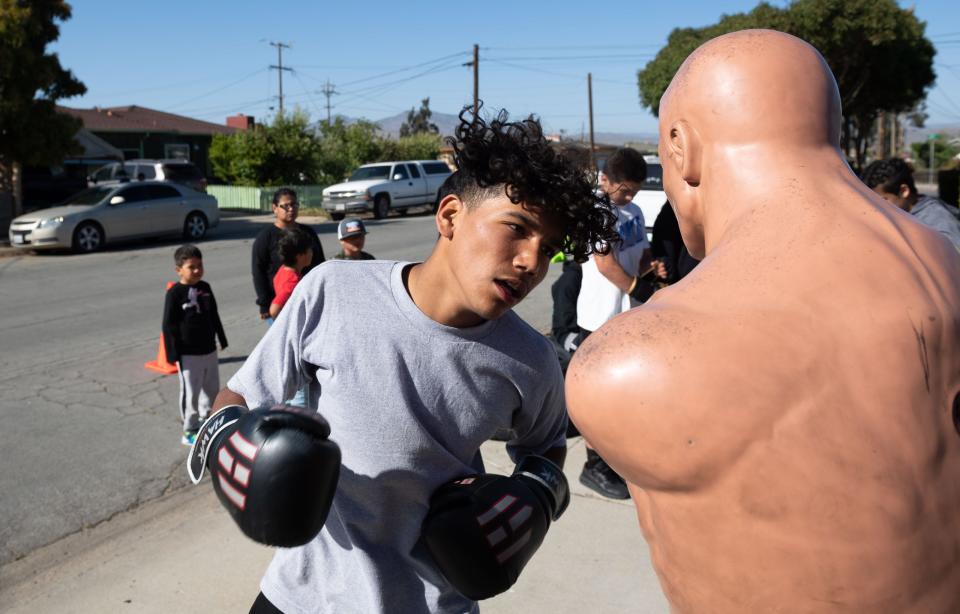 Damian Cerna Jr., a member of A.V.I.L.A Victory Boxing punches a boxing mannequin during a training boxing session outside a home garage in Greenfield, Calif., on Wednesday, May 4, 2022.