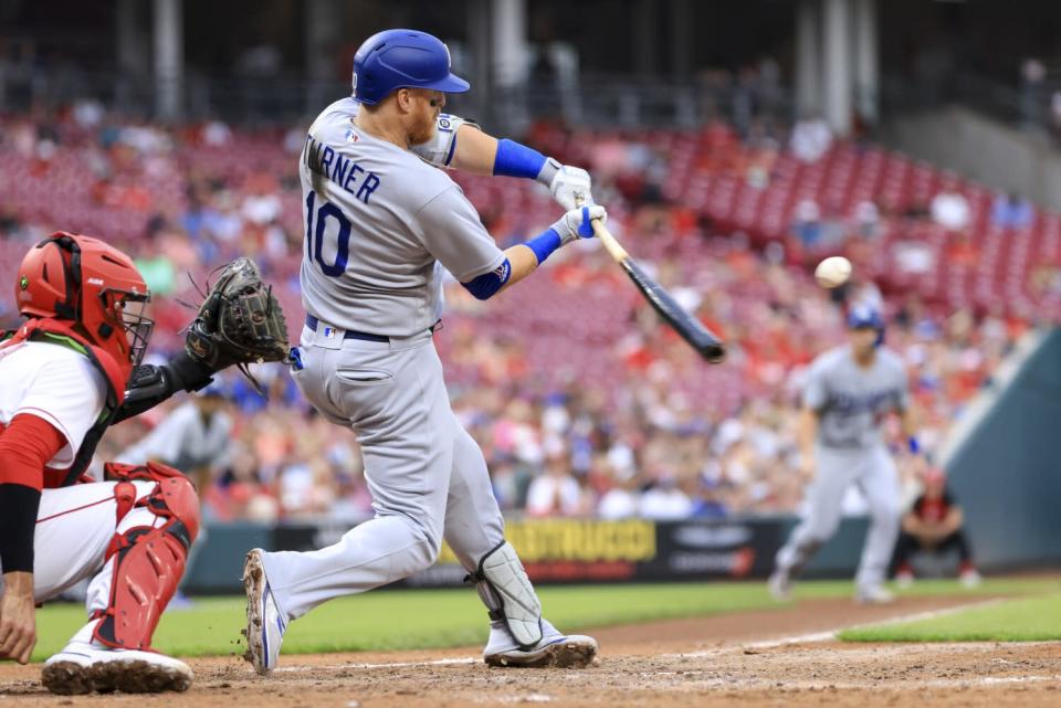 The Dodgers' Justin Turner hits a sacrifice fly against the Reds on Wednesday.