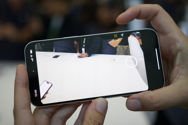 Someone using the Camera Control button on the iPhone 16.