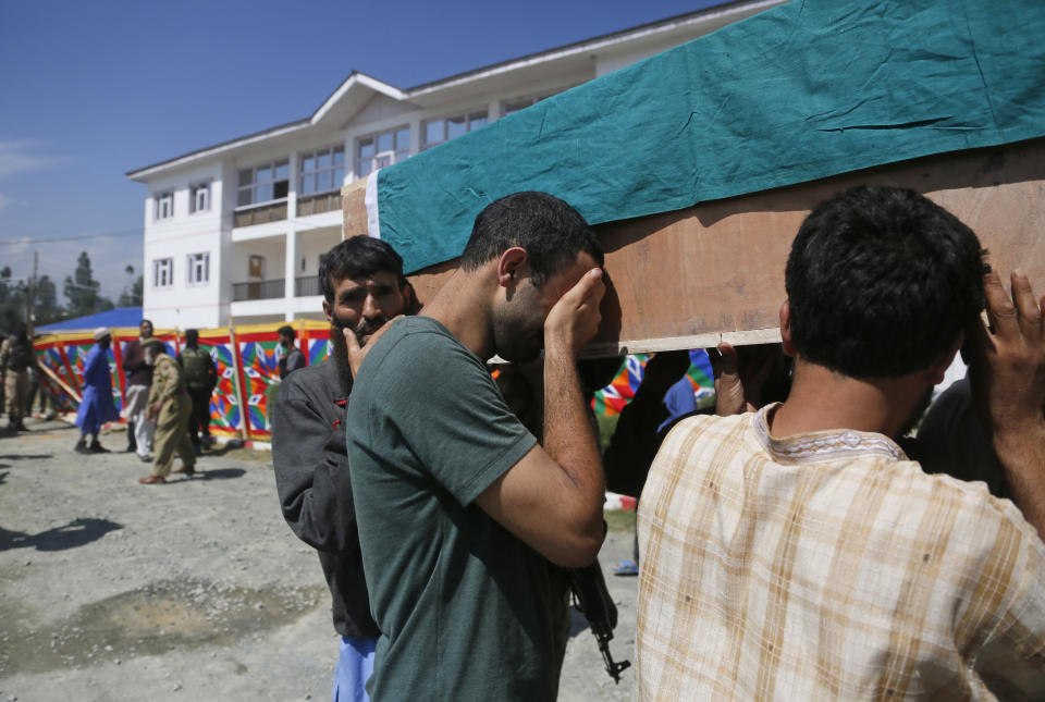 An unidentified man cries as he carries the coffin of a relative, a slain policeman, during a wreath laying ceremony at a base camp at shopian, about 63 kilometers south of Srinagar, Indian controlled Kashmir, Friday, Sept. 21, 2018. Anti-India rebels in disputed Kashmir raided over a dozen homes of police officers and abducted three whose bullet-riddled were recovered Friday, officials said. The killings came days after the region's largest rebel group asked officers to quit the Kashmiri police force and stay away from counterinsurgency operations. (AP Photo/Mukhtar Khan)