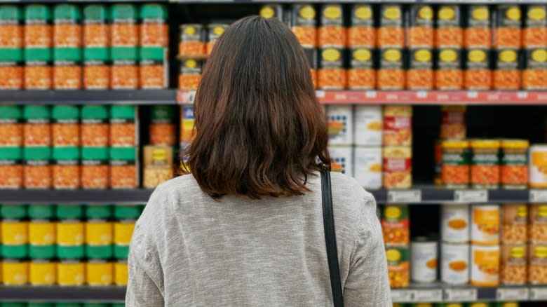 Person perusing canned foods