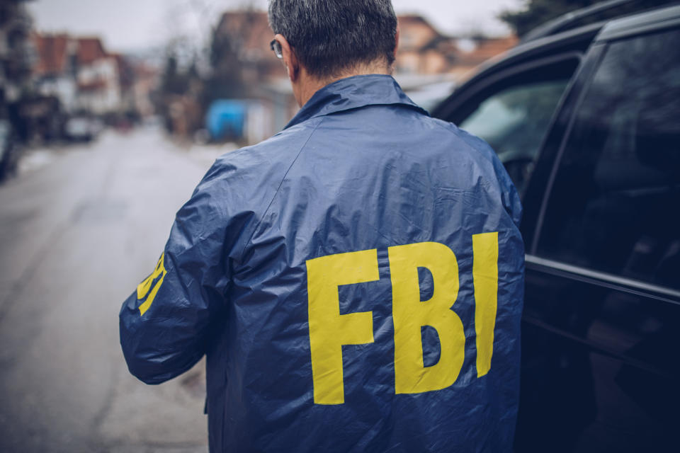 An FBI agent next to a van