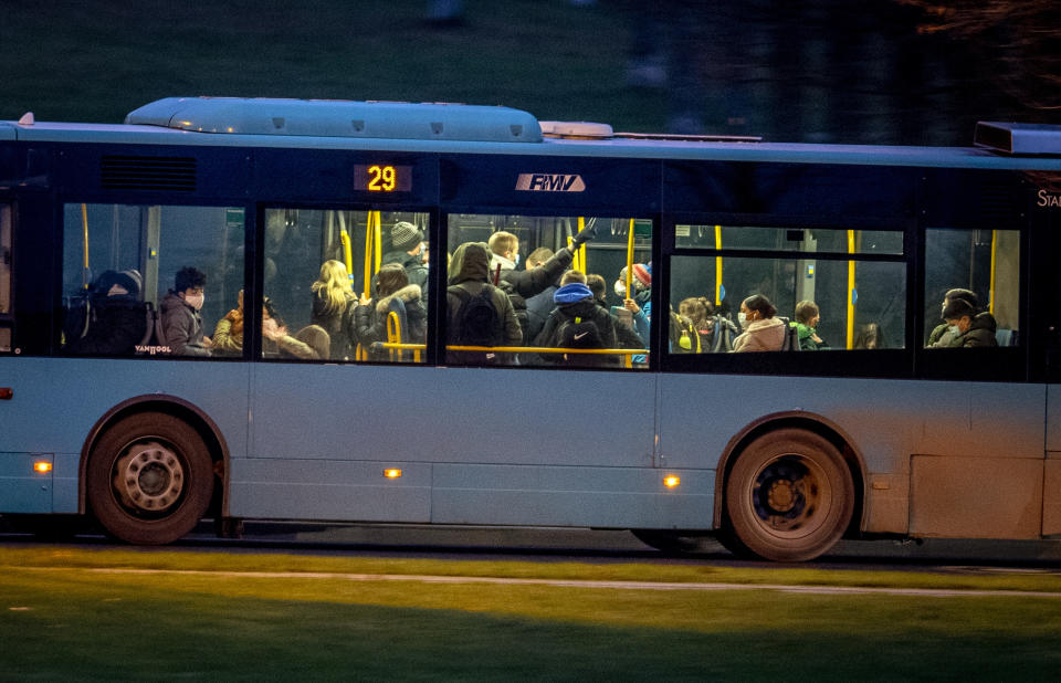 People drive in a bus in Frankfurt, Germany, Monday, Dec. 14, 2020. Germany goes into a lockdown on Wednesday, Dec. 16, 2020. (AP Photo/Michael Probst)