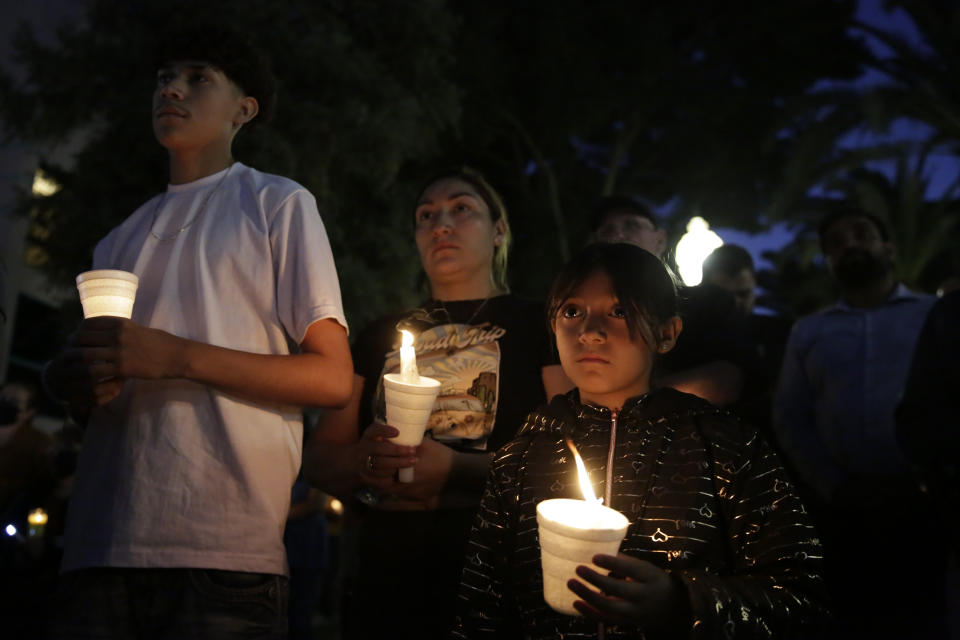 Monserrat Herrera, right, 8, Yubicela Sanchez, center, and Christopher Herrera, left, 17, attend a candlelight vigil for the Singh family at Bob Hart Square in Merced, Calif., on Thursday, Oct. 6, 2022. Four members of the Singh family were abducted and killed this week. The suspect in the kidnapping and killings of an 8-month-old baby, her parents and an uncle had worked for the family’s trucking business and had a longstanding feud with them that culminated in an act of “pure evil,” a sheriff said Thursday. (Salgu Wissmath/San Francisco Chronicle via AP)